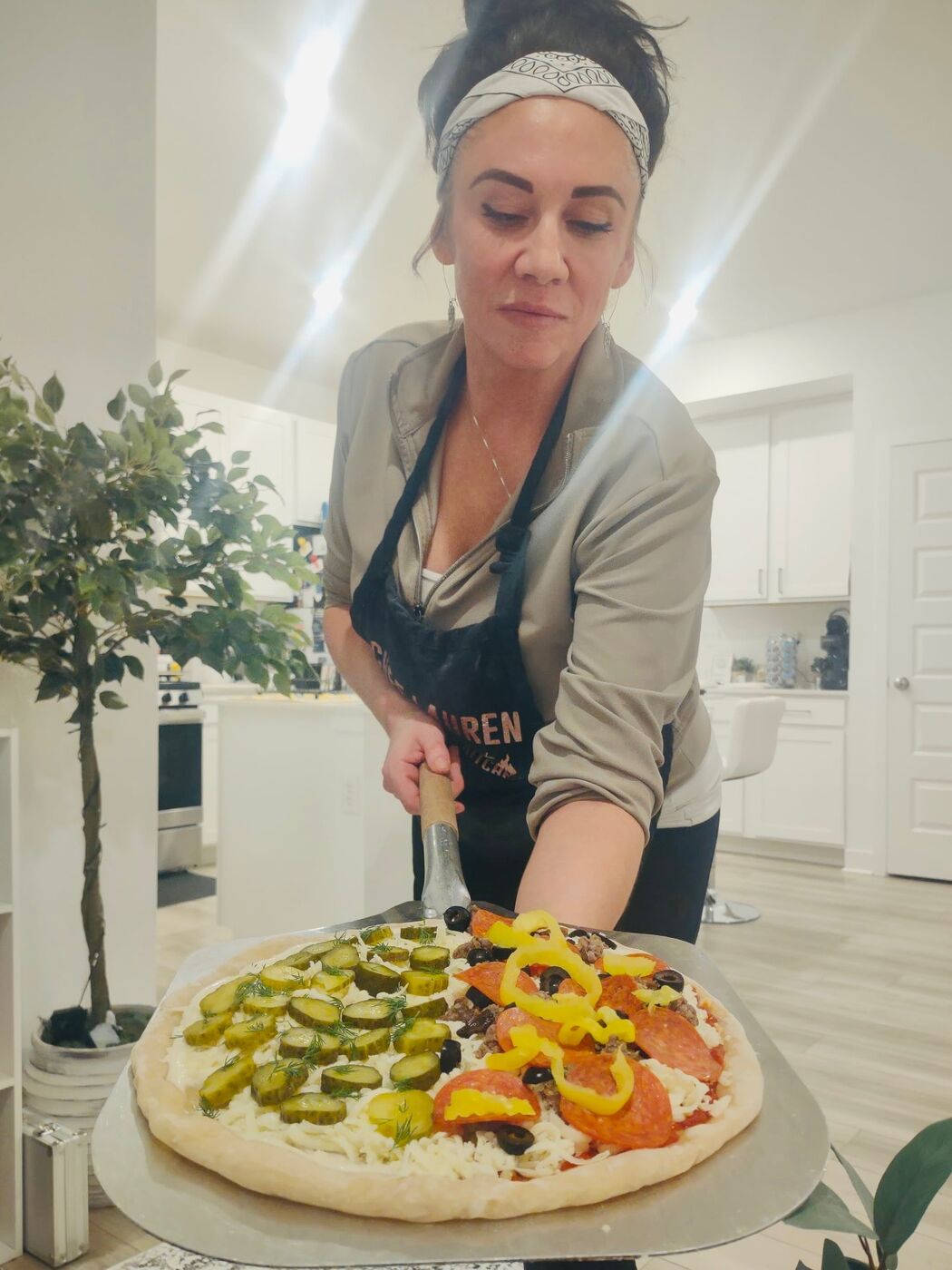 Lauren garnishing a fresh margherita pizza